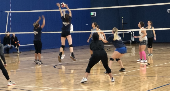 Recreation volleyball teams playing hard at the net.