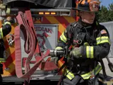 Firefighter pulling hose from a firetruck