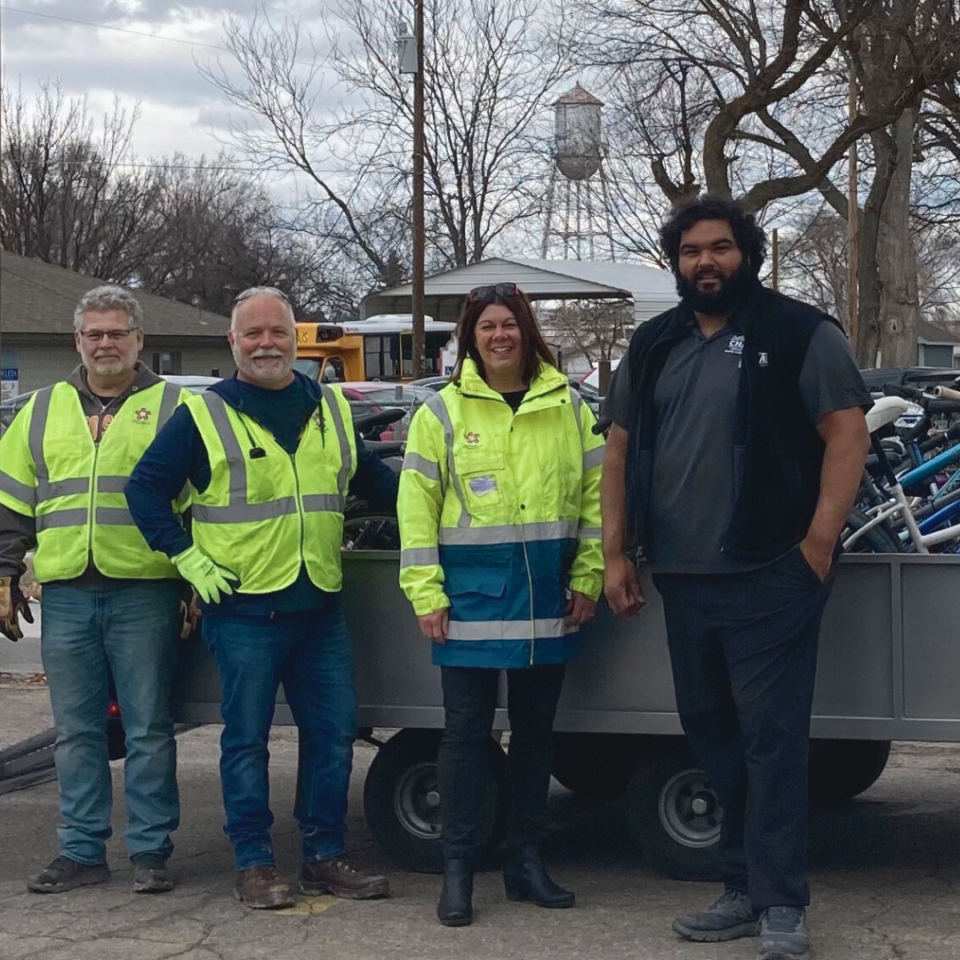 Solids Waste Advisory Committee members and Republic Services employees standing in front of a trailer full of bikes that they fixed as volunteers